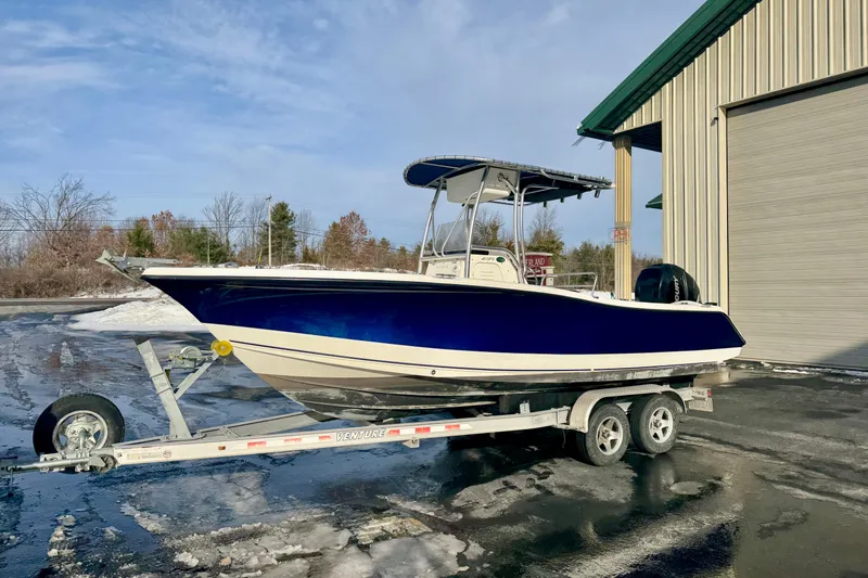 Slide: The Image of 2010 Trophy 2203 Center Console boat on trailer, parked outside a building. - 0