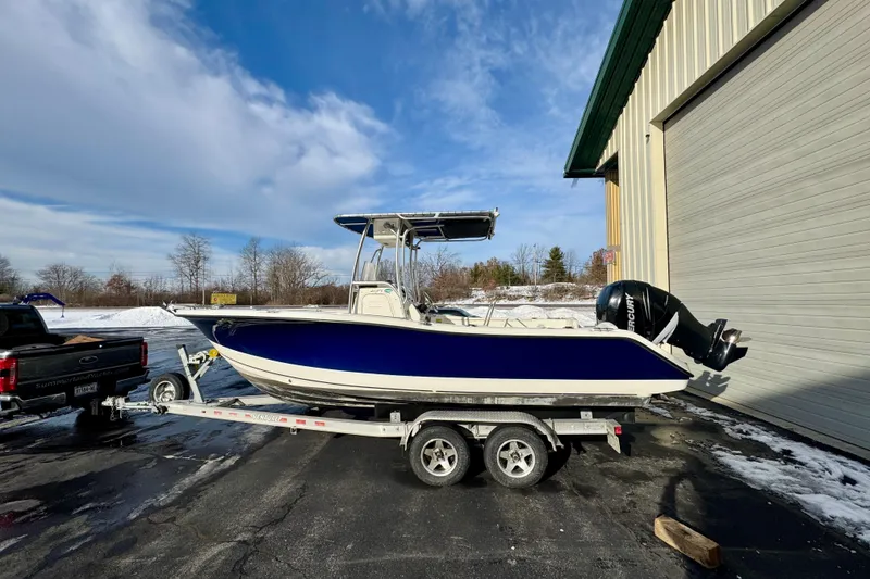 Slide: The Image of 2010 Trophy 2203 Center Console boat on trailer, parked outdoors near a building. - 2