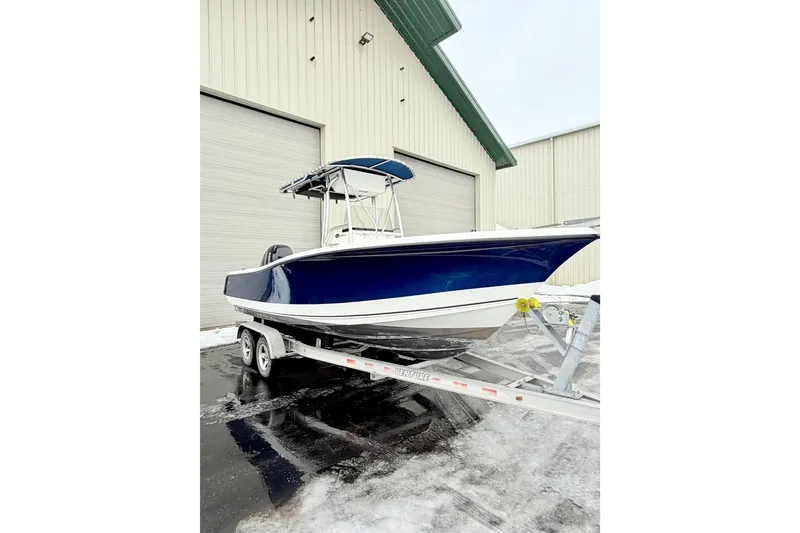 Slide: The Image of 2010 Trophy 2203 Center Console boat on trailer near warehouse. - 3