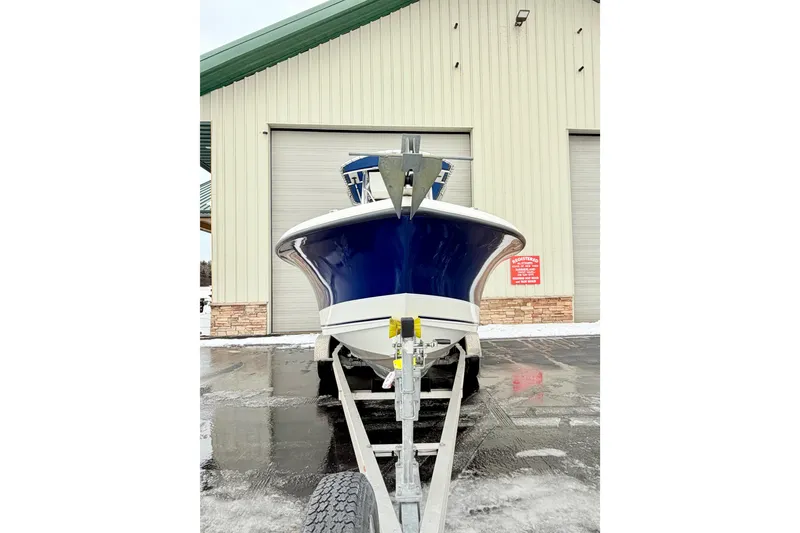 Slide: The Image of 2010 Trophy 2203 Center Console boat on trailer, parked outside a large garage. - 4