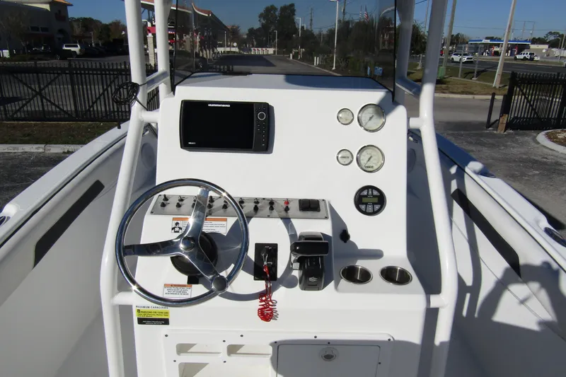 Slide: The Image of 2019 Clearwater Sportfishing Boats 2200 CC console with steering wheel and navigation system. - 16
