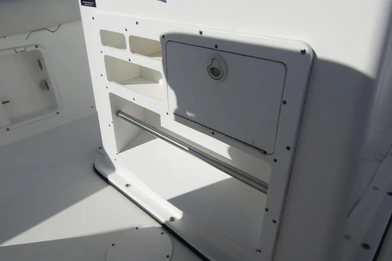 Slide: The Image of 2019 Clearwater Sportfishing Boats 2200 CC console storage compartment, white interior design. - 21