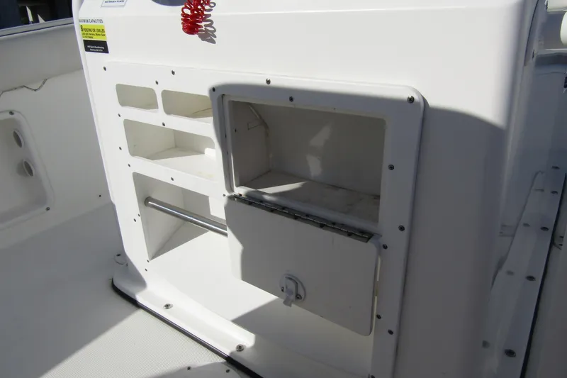 Slide: The Image of 2019 Clearwater Sportfishing Boats 2200 CC console storage compartment, white interior. - 22