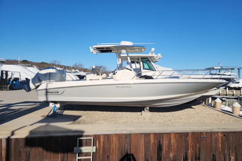 Slide: The Image of 2018 Boston Whaler 270 Dauntless boat on display at a marina under clear blue skies. - 14