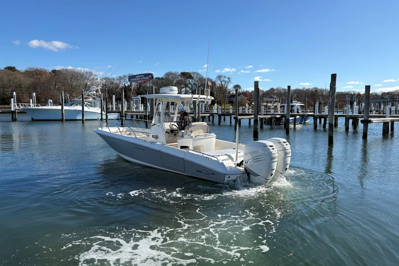 Slide: The Image of 2018 Boston Whaler 270 Dauntless boat navigating marina waters under clear blue sky. - 19