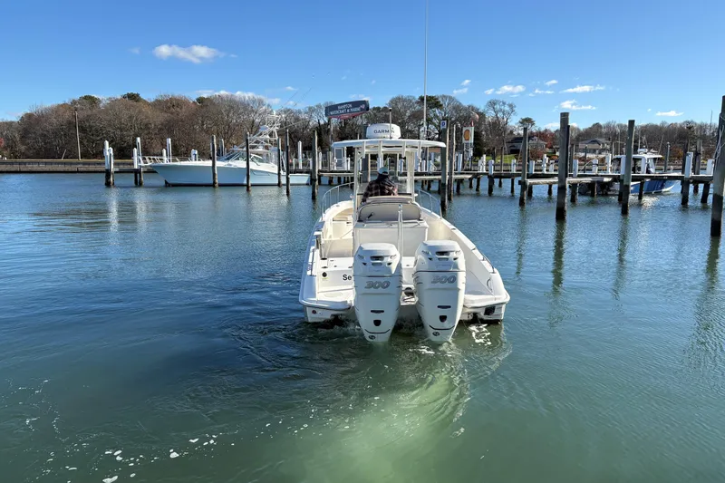 Slide: The Image of 2018 Boston Whaler 270 Dauntless boat docked in a serene marina setting. - 2