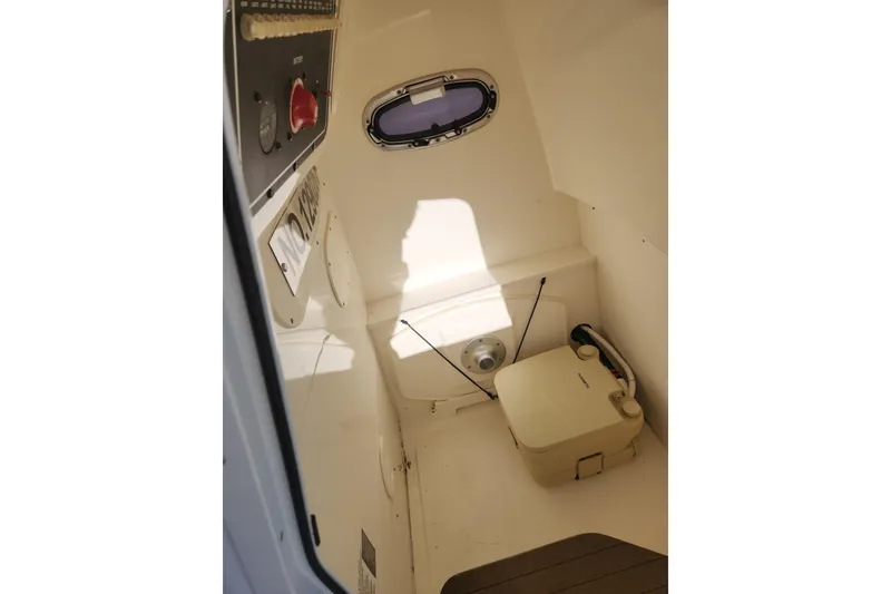 Slide: The Image of Interior of 2018 Boston Whaler 270 Dauntless boat with compact toilet and control panel. - 9
