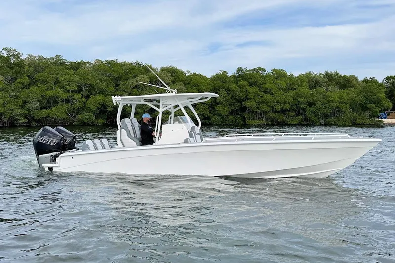 Slide: The Image of 2023 Concept 30' Cuddy Cabin boat cruising on water near lush green shoreline. - 6