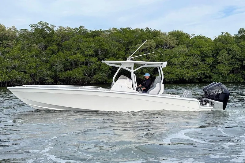 Slide: The Image of 2023 Concept 30' Cuddy Cabin boat cruising on water near lush green trees. - 7