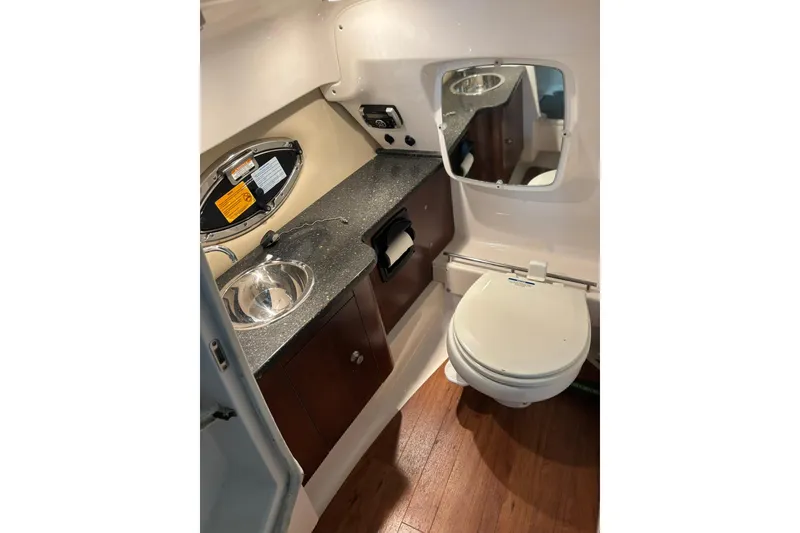 Slide: The Image of 2016 Chaparral 287 SSX boat bathroom with sink, mirror, and toilet. - 14