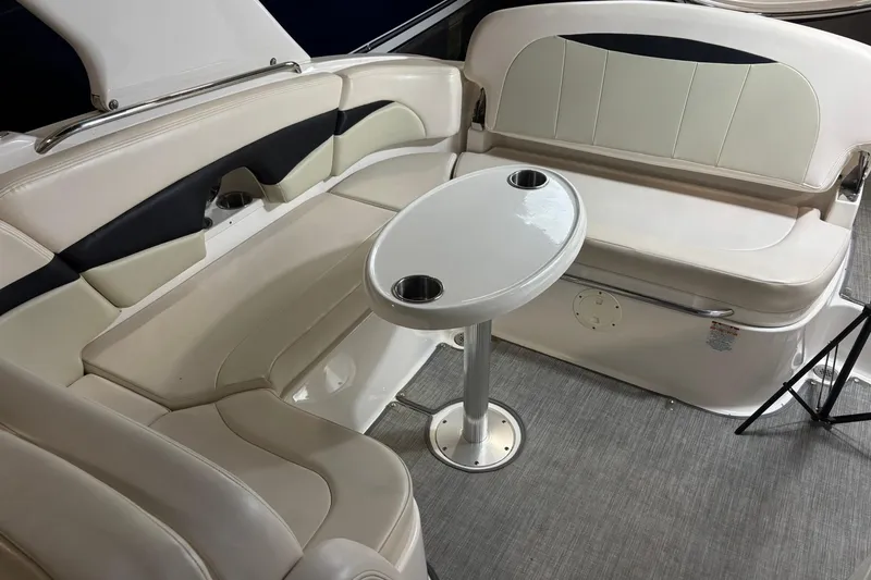 Slide: The Image of 2016 Chaparral 287 SSX boat interior with beige seating and round table. - 24