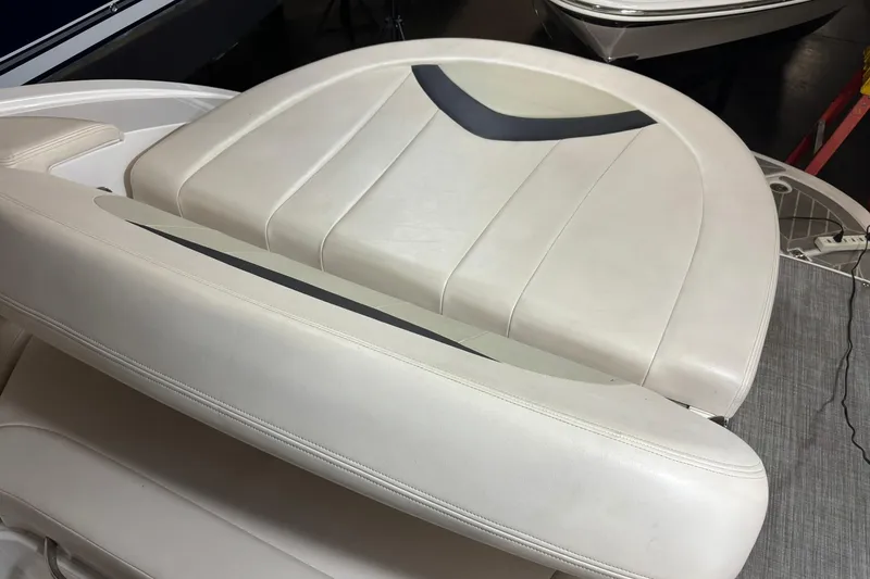 Slide: The Image of 2016 Chaparral 287 SSX boat interior seating, featuring sleek white upholstery. - 25
