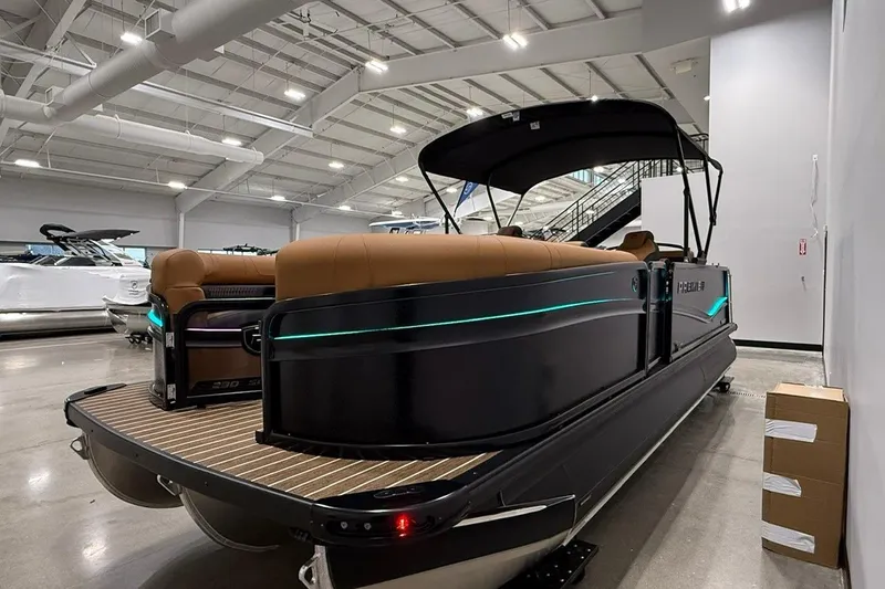 Slide: The Image of 2026 Premier 230 SOLARIS RL-CL pontoon boat in showroom, featuring sleek design and ambient lighting. - 4