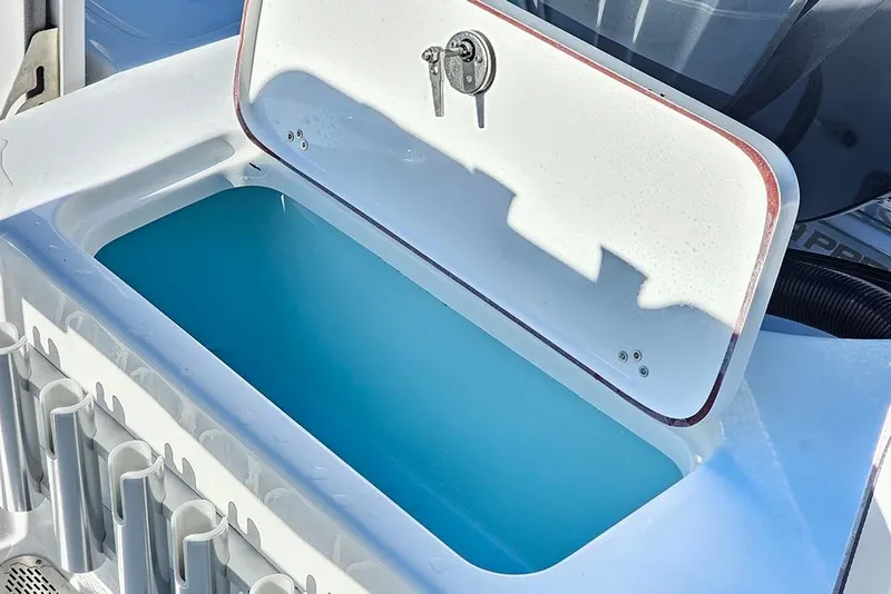 Slide: The Image of Livewell on 2026 Sea Pro 210 Bay boat, featuring rod holders and key lock. - 15