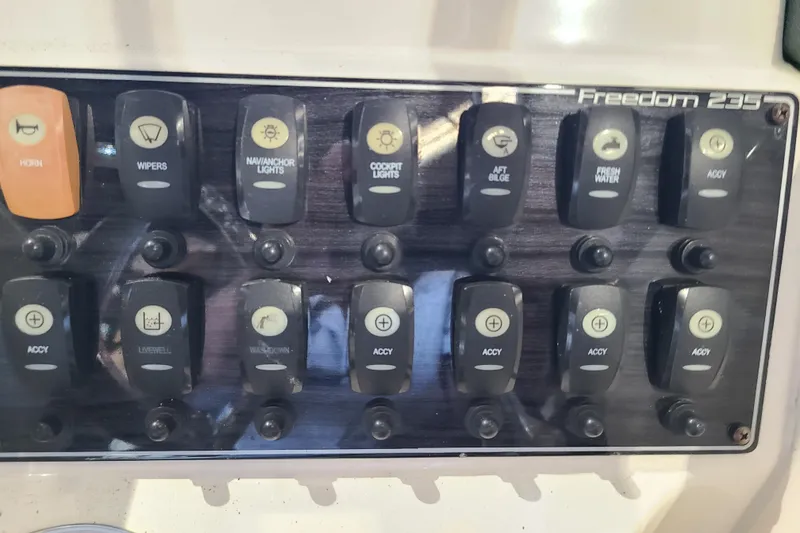 Slide: The Image of Control panel of a 2017 Grady-White Freedom 235 boat with labeled switches. - 10