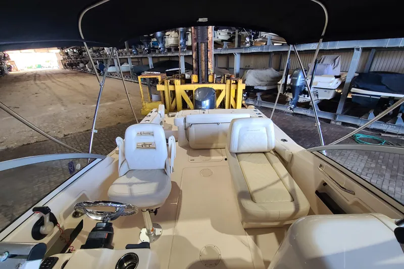Slide: The Image of 2017 Grady-White Freedom 235 boat interior with seating and steering wheel in storage facility. - 17
