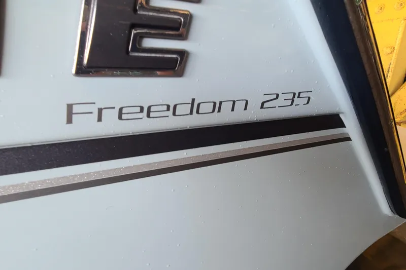 Slide: The Image of 2017 Grady-White Freedom 235 boat model name on hull with sleek design. - 2