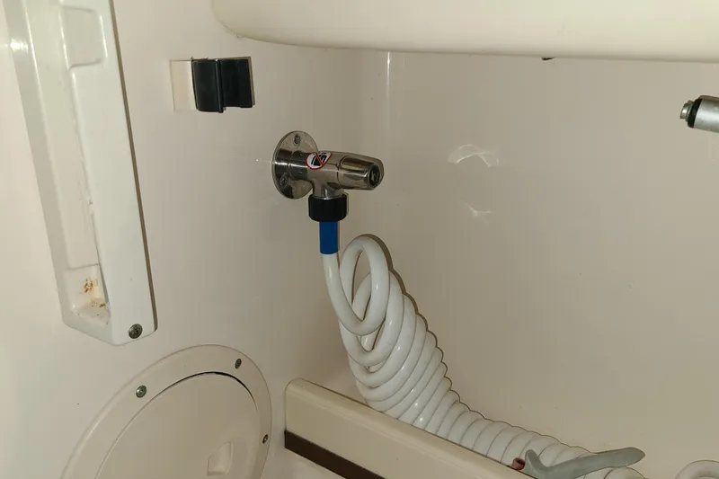 Slide: The Image of 2017 Grady-White Freedom 235 boat interior with coiled hose and faucet. - 25