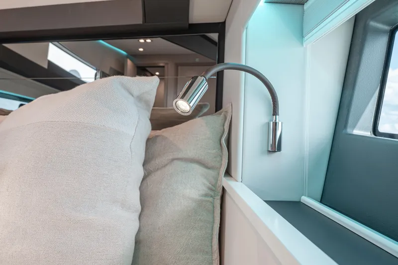 Slide: The Image of Interior of 2026 Fjord 490 SPORT yacht with modern reading light and cushions. - 46