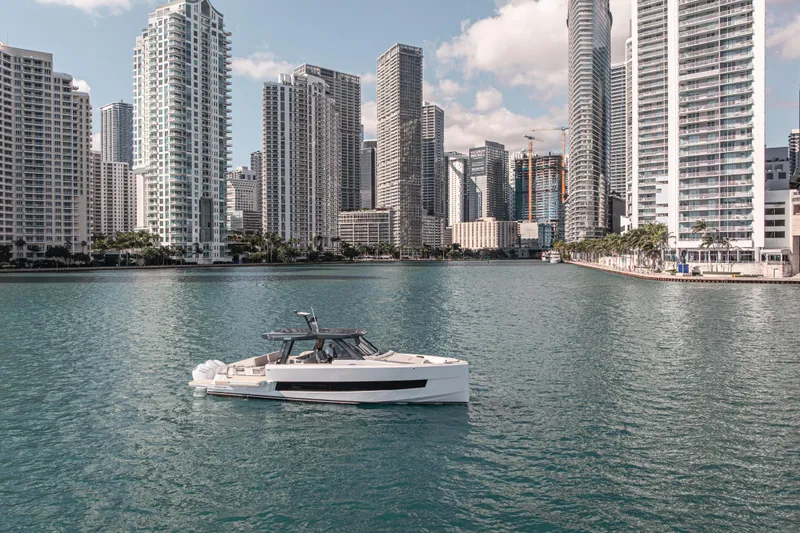 Slide: The Image of Fjord 490 SPORT 2026 yacht cruising near urban skyline, calm waters, modern architecture. - 7