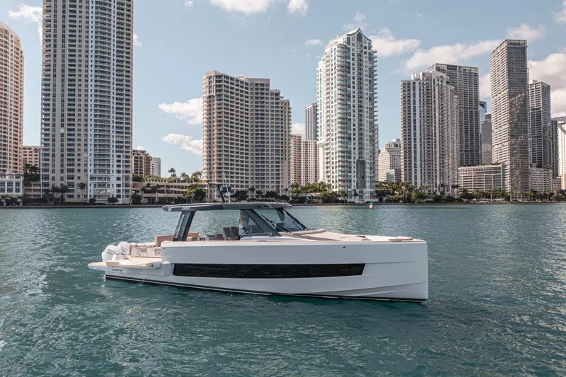 Slide: The Image of 2026 Fjord 490 SPORT yacht cruising near city skyline, modern luxury boat on water. - 5