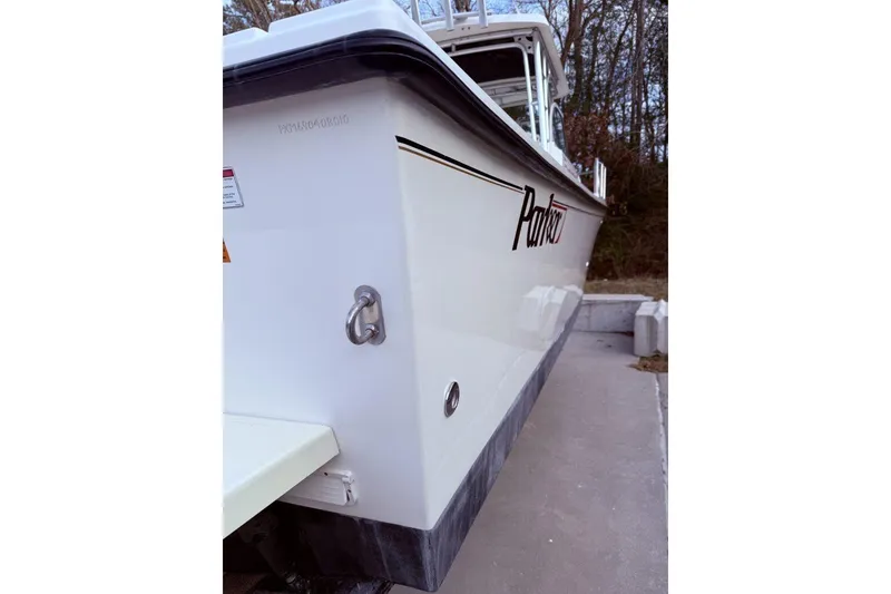 Slide: The Image of 2010 Parker 2510 XL Walkaround boat, side view, docked on concrete. - 2