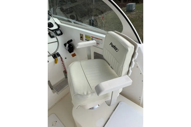 Slide: The Image of Captain's seat on 2010 Parker 2510 XL Walkaround boat, featuring steering wheel and controls. - 5