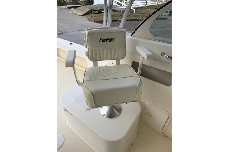 Slide: The Image of Captain's chair on 2010 Parker 2510 XL Walkaround boat, featuring white upholstery. - 7