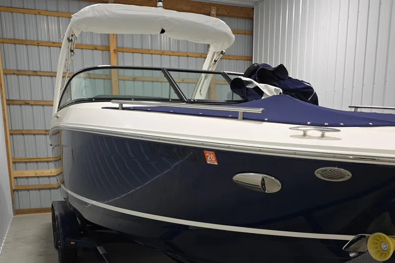 Slide: The Image of 2023 Regal LS4 boat in storage, featuring sleek design and navy blue hull. - 0
