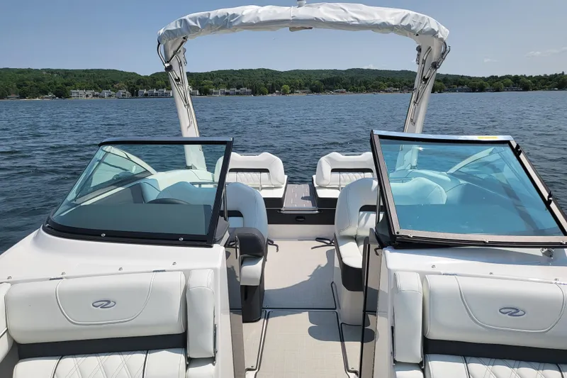 Slide: The Image of 2023 Regal LS4 boat interior with open windshield on a scenic lake. - 24