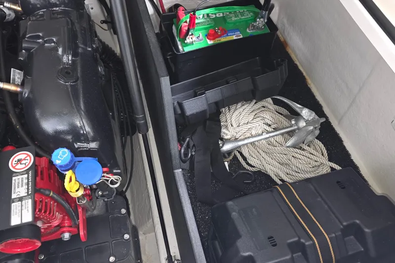Slide: The Image of 2023 Regal LS4 boat engine compartment with battery, anchor, and rope. - 28