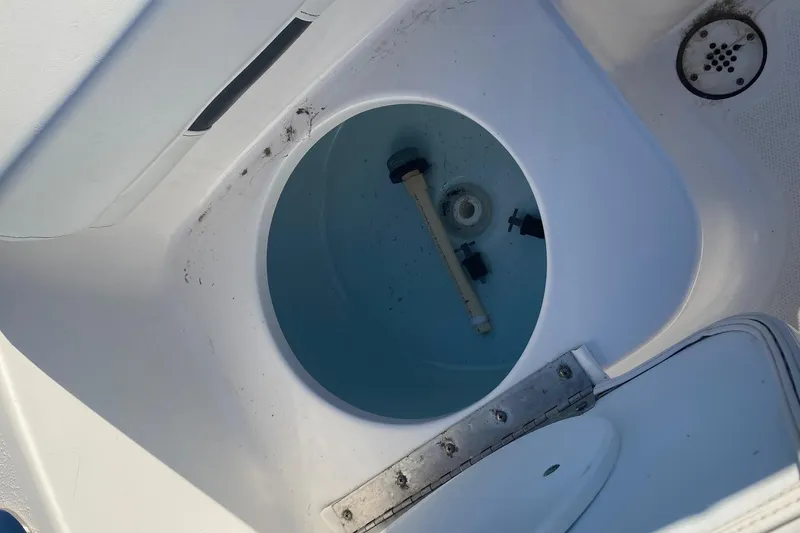 Slide: The Image of Livewell compartment in a 2014 Tidewater 196 CC Adventure boat, featuring a drain and hinge. - 11