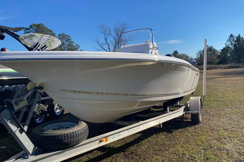 Slide: The Image of 2014 Tidewater 196 CC Adventure boat on trailer, parked on grass under clear blue sky. - 12