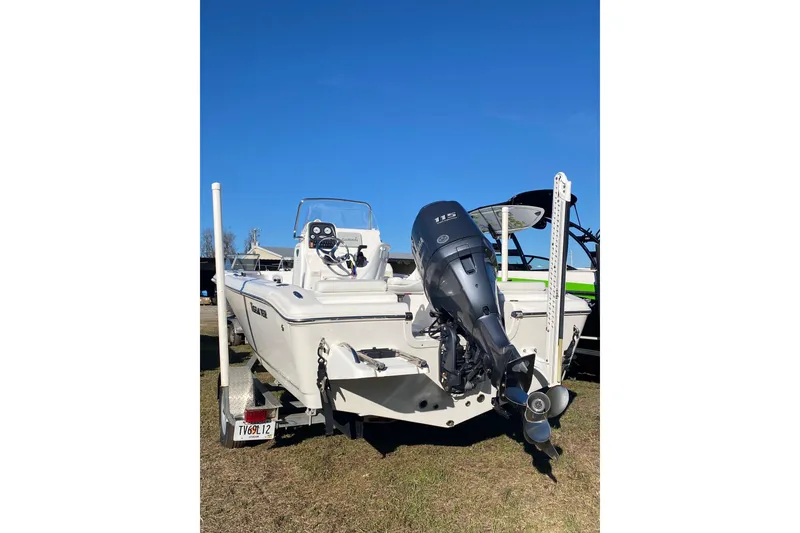 Slide: The Image of 2014 Tidewater 196 CC Adventure boat with outboard motor, parked on grass. - 2