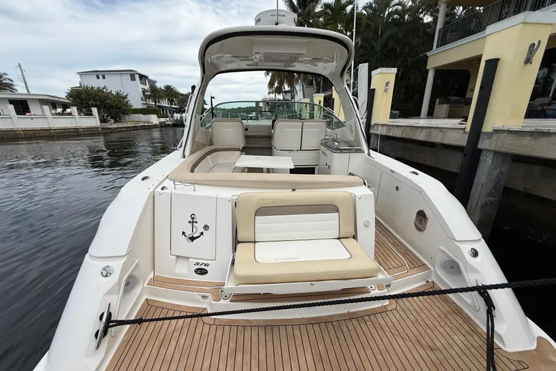 Slide: The Image of 2012 Sea Ray 370 Sundancer yacht docked, featuring spacious seating and elegant design. - 13
