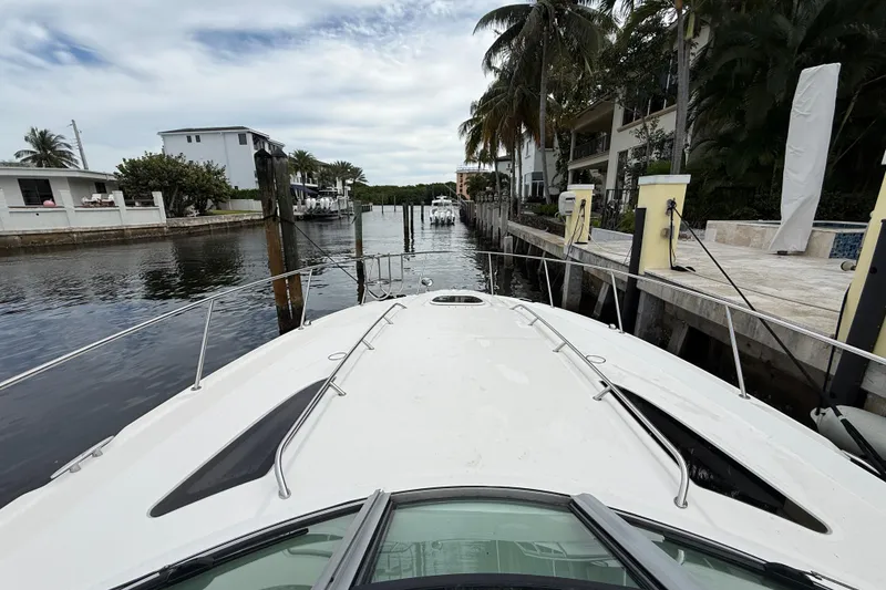 Slide: The Image of 2012 Sea Ray 370 Sundancer docked in a scenic canal with palm trees. - 20