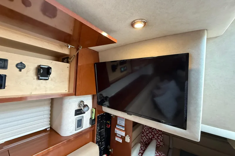 Slide: The Image of Interior of 2012 Sea Ray 370 Sundancer with TV and wooden cabinetry. - 33