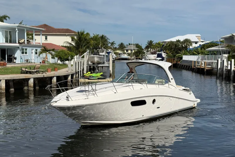 Slide: The Image of 2012 Sea Ray 370 Sundancer cruising in a scenic canal with waterfront homes. - 8