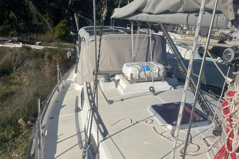 Slide: The Image of 1984 Morgan 384 sailboat deck with rigging and equipment, docked in a marina. - 11