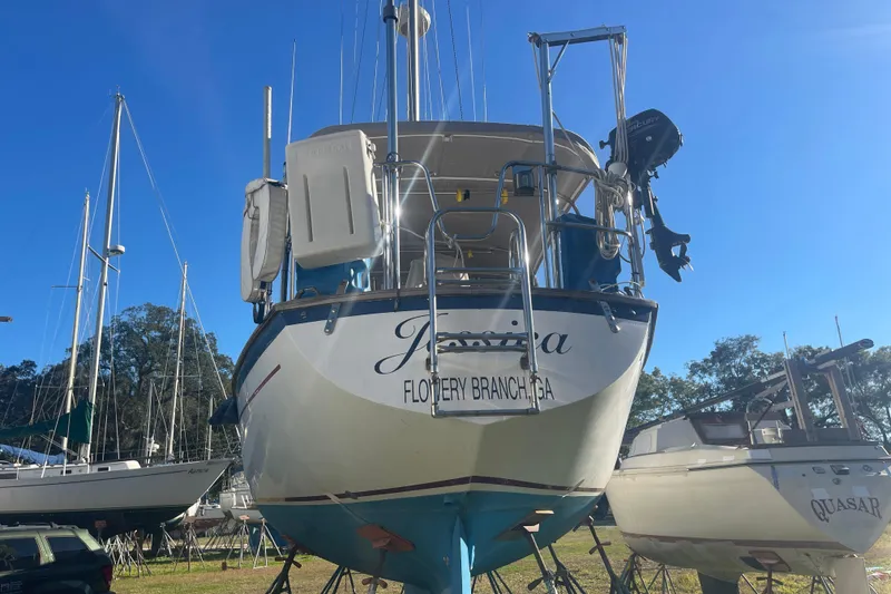 Slide: The Image of 1984 Morgan 384 sailboat named "Jessica" in a boatyard under clear blue skies. - 2