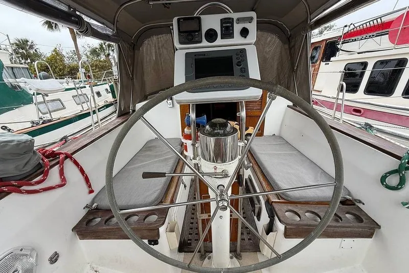 Slide: The Image of 1984 Morgan 384 sailboat cockpit with steering wheel and navigation equipment. - 21