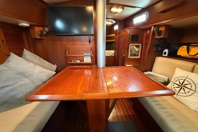 Slide: The Image of Interior of a 1984 Morgan 384 sailboat with wooden table and cozy seating. - 28