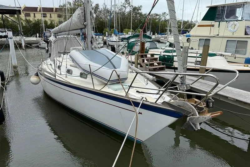 Slide: The Image of 1984 Morgan 384 sailboat docked in a marina, surrounded by other boats. - 3