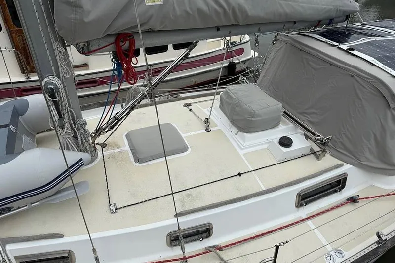 Slide: The Image of 1984 Morgan 384 sailboat deck with rigging, solar panels, and covered equipment. - 31