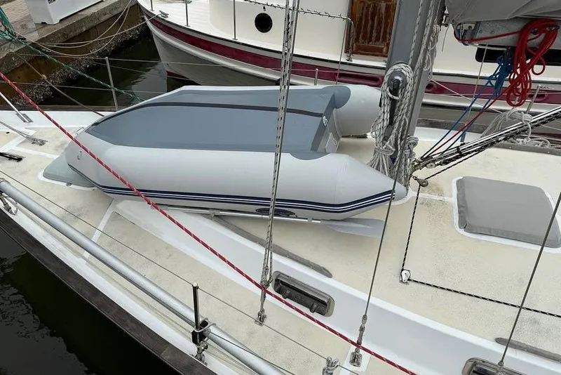 Slide: The Image of 1984 Morgan 384 sailboat with inflatable dinghy on deck, docked at marina. - 32