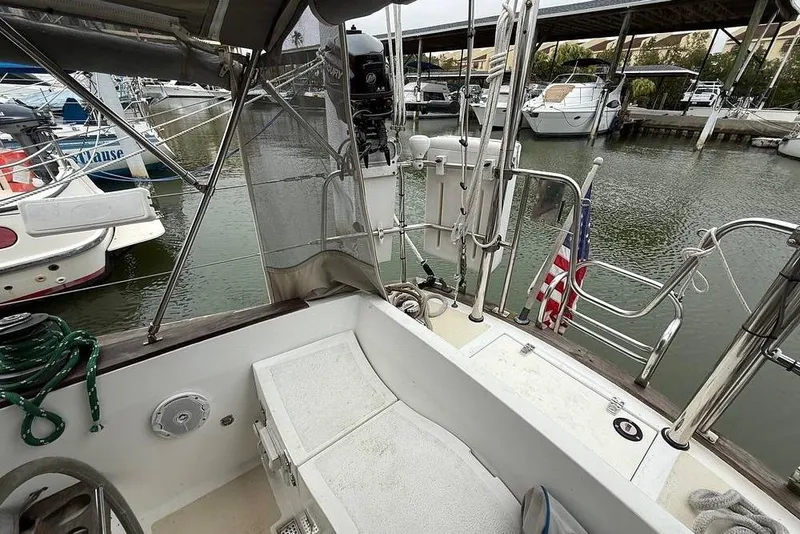 Slide: The Image of 1984 Morgan 384 sailboat docked at marina, featuring cockpit and American flag. - 34