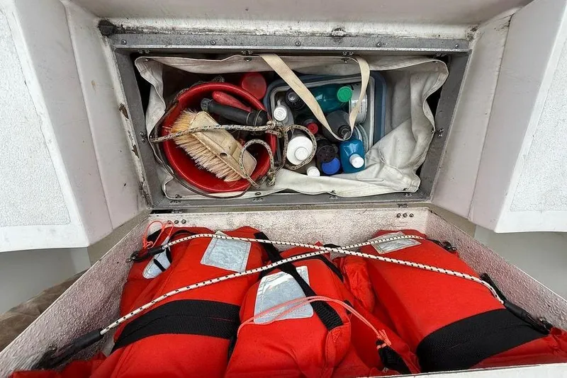 Slide: The Image of Storage compartment on a 1984 Morgan 384 sailboat with life jackets and cleaning supplies. - 38