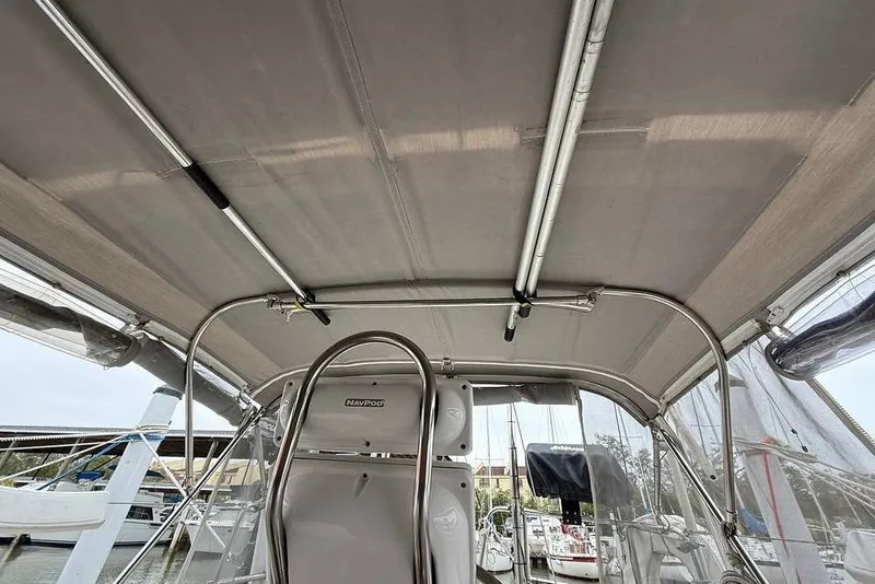 Slide: The Image of 1984 Morgan 384 sailboat cockpit with canopy and steering wheel, docked at marina. - 47