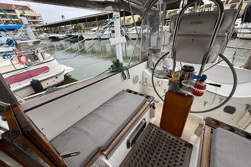 Slide: The Image of 1984 Morgan 384 sailboat cockpit with steering wheel, docked in marina. - 51