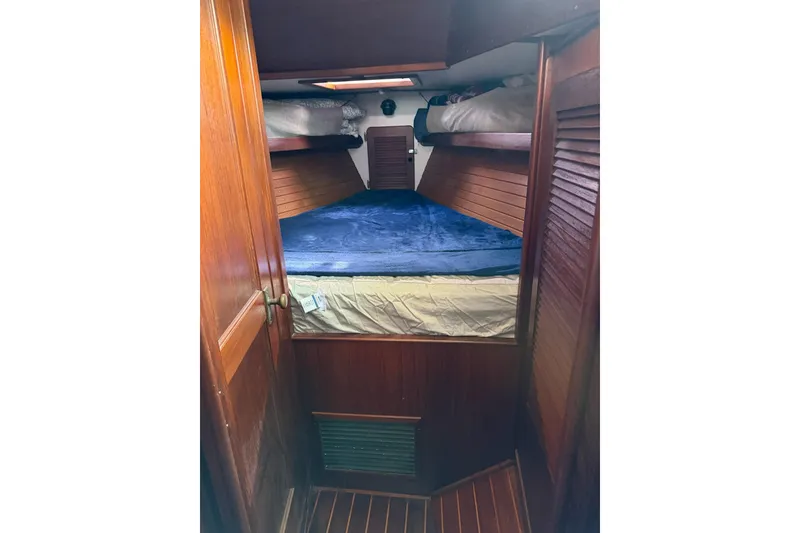 Slide: The Image of Cozy cabin interior of 1984 Morgan 384 sailboat with wooden finish and blue bedding. - 55